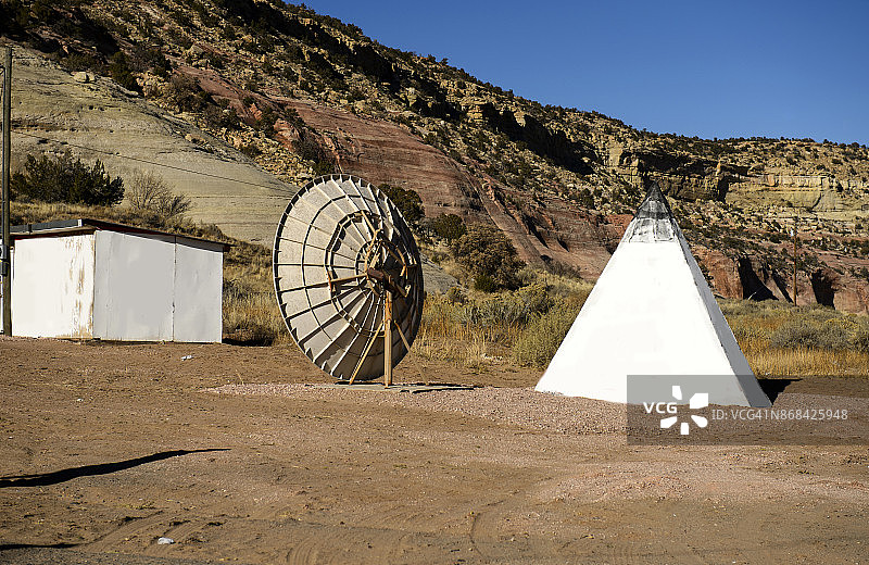 位于美国亚利桑那州卢普顿的卫星天线和印第安圆锥形帐篷图片素材