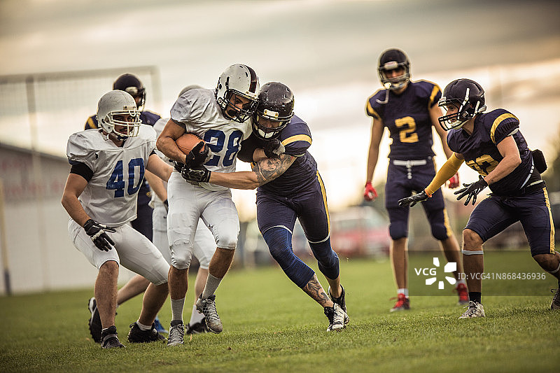橄榄球场上比赛中的一群美式橄榄球运动员图片素材