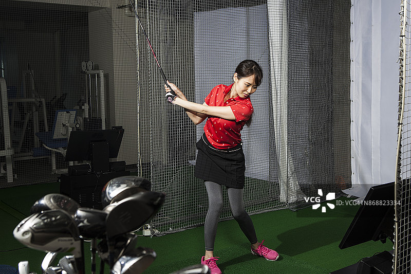 女人在高尔夫球馆练习图片素材