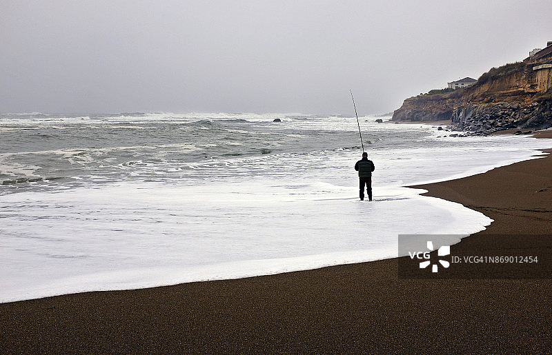 男人在冲浪区钓鱼图片素材