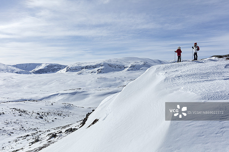 在HALLINGSKARVET_NORWAY欣赏风景的滑雪者图片素材