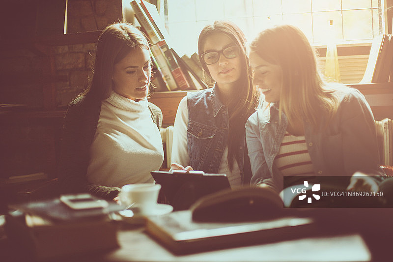 在图书馆一起做作业的快乐女学生图片素材