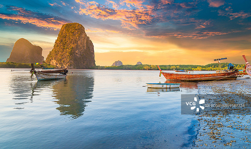 美丽的日落在热带海洋与长尾船在泰国南部图片素材