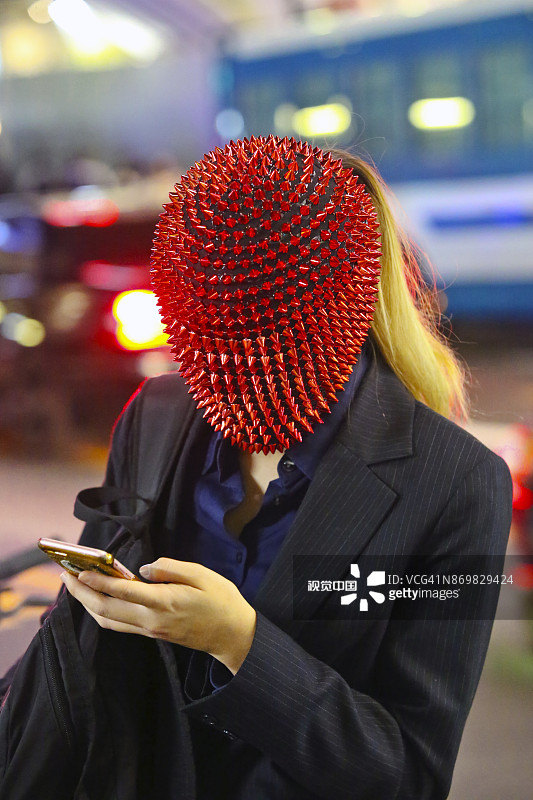 戴口罩在智能手机上轻点屏幕的女人图片素材