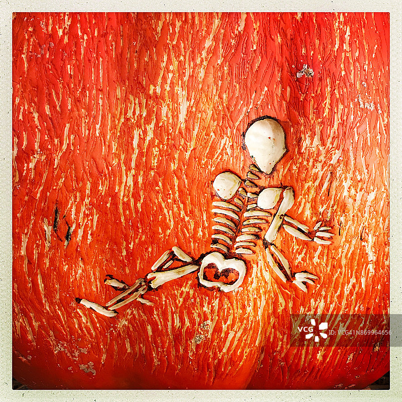 万圣节南瓜上的手工雕刻骷髅图片素材