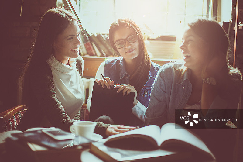 女学生在图书馆里进行有趣的对话（特写）图片素材