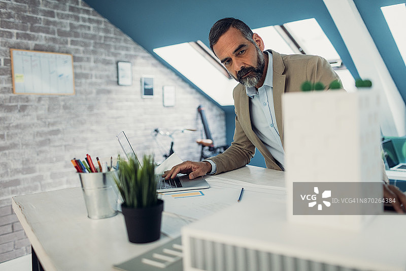 在办公室工作的年长的男建筑师图片素材