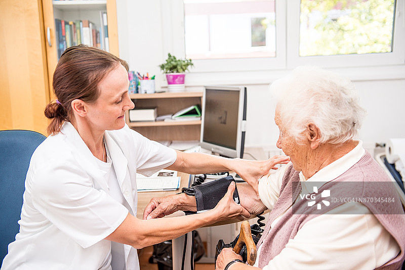 年长的妇女在接受医生体检图片素材