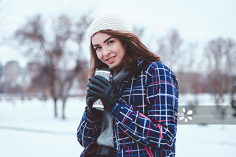 在下雪天享用热饮的迷人女人图片素材