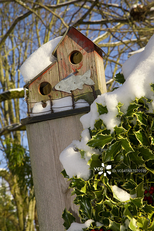 冬季栖息在围栏柱上的鸟屋图片素材