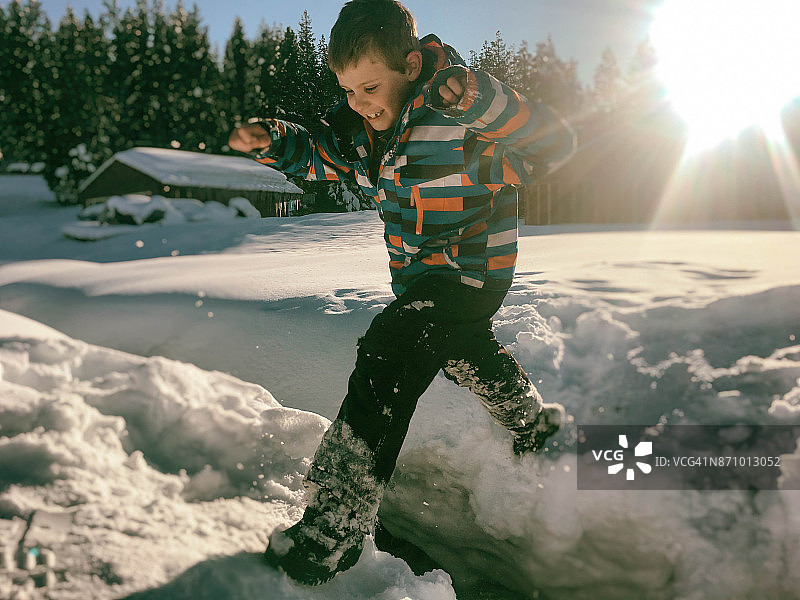 男孩在雪地里跳跃图片素材