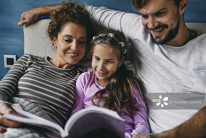 父母和女儿一起读书图片素材