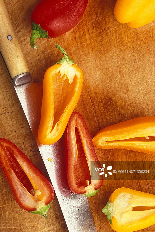 切菜板上切成两半的墨西哥辣椒与古董刀图片素材