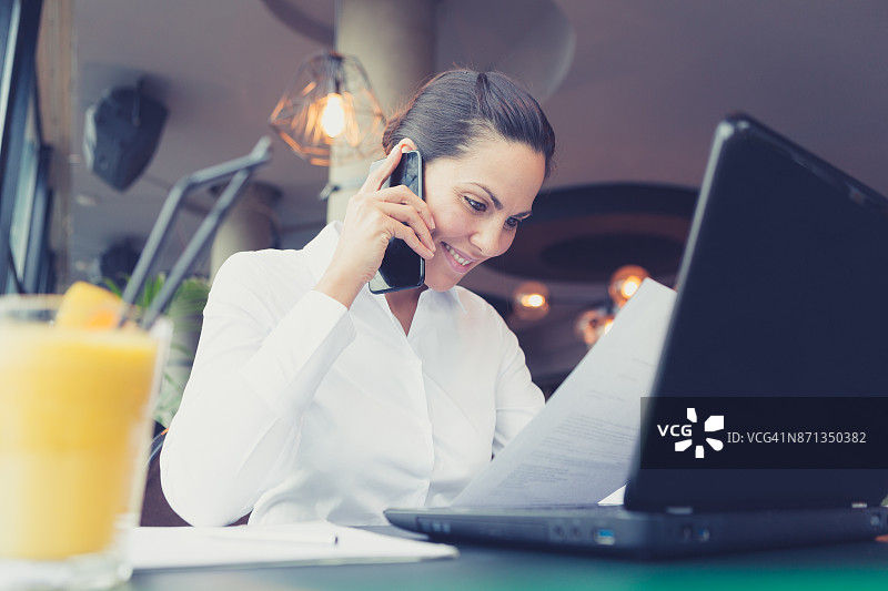 在咖啡馆使用手机的商务女人（贝尔格莱德，塞尔维亚）图片素材