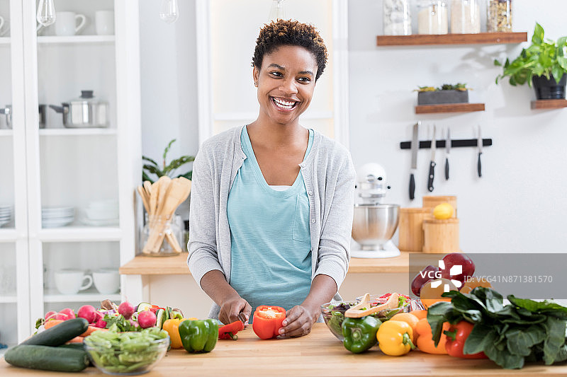 快乐的女人在厨房切菜图片素材