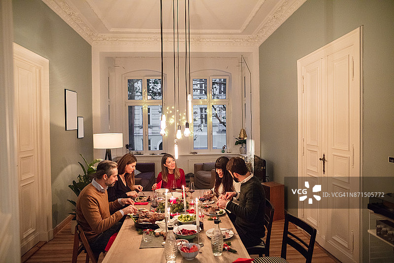 男人和女人们在家中享受圣诞晚宴图片素材