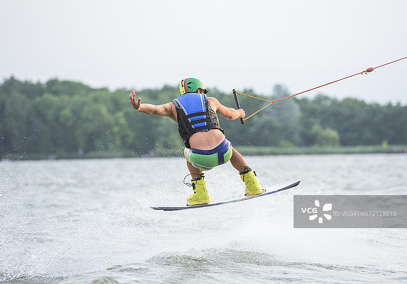 在湖上玩尾波滑板的男子图片素材