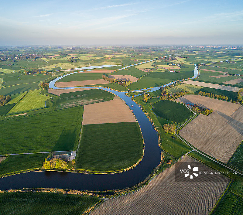 空中俯瞰，河流的自然弯曲，四周环绕着荷兰的农耕景观图片素材