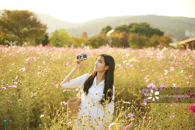 年轻女人在宇宙田中拍照图片素材