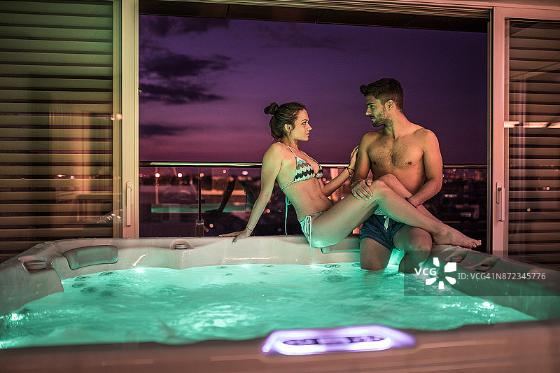 年轻夫妇在顶层公寓的热水浴缸里坠入爱河图片素材