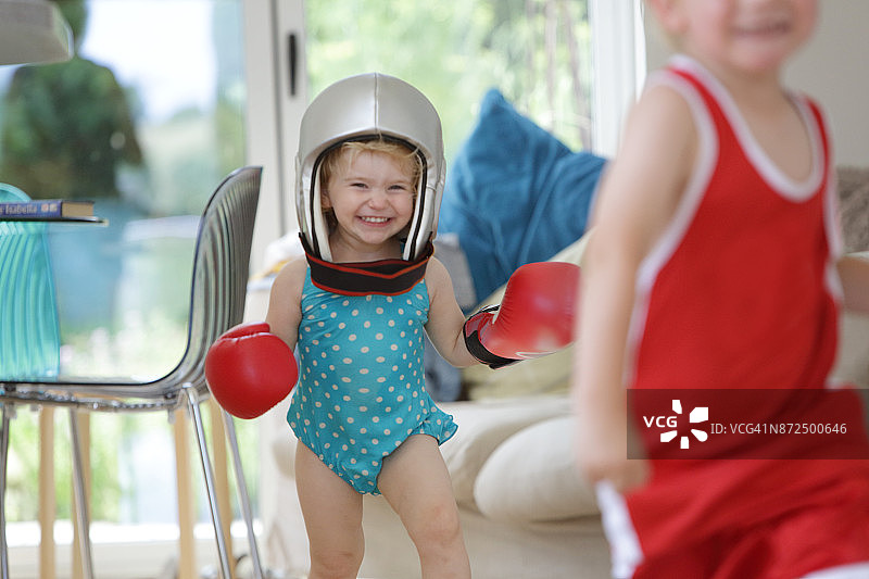 幼儿追逐穿着泳衣和拳击服的哥哥图片素材