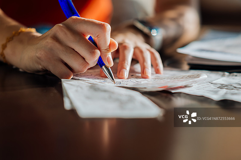 女人手持圆珠笔和收据图片素材