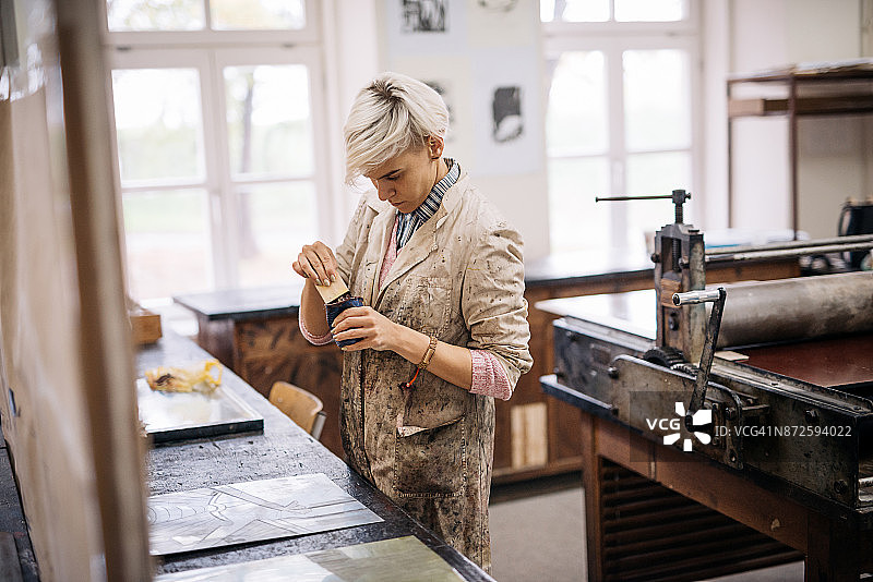 在蚀刻金属板上涂抹墨水图片素材