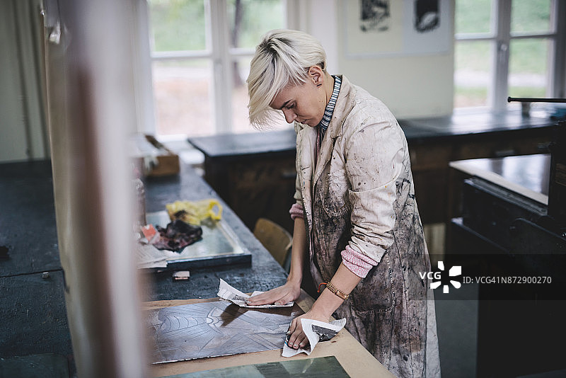 专业艺术家正在制作新的蚀刻金属板图片素材