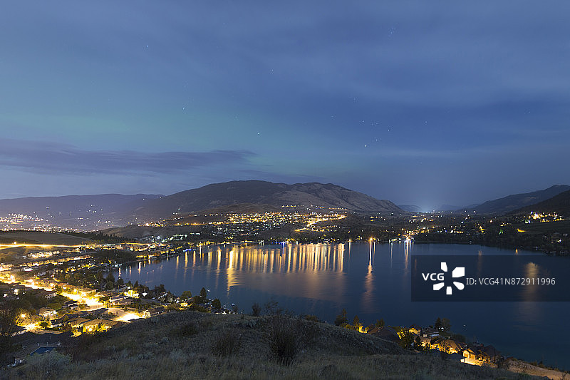 加拿大不列颠哥伦比亚省城镇上空的城市灯光和北极光图片素材