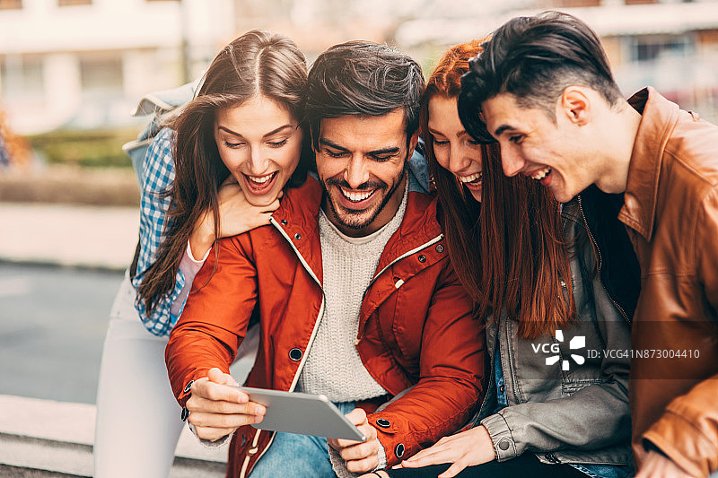 朋友们在城市里使用平板电脑图片素材