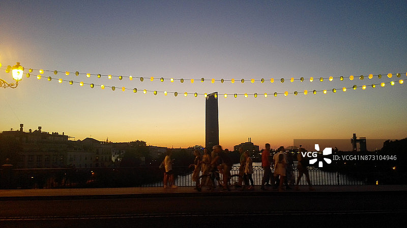夜幕降临时人们穿过特里亚纳桥图片素材