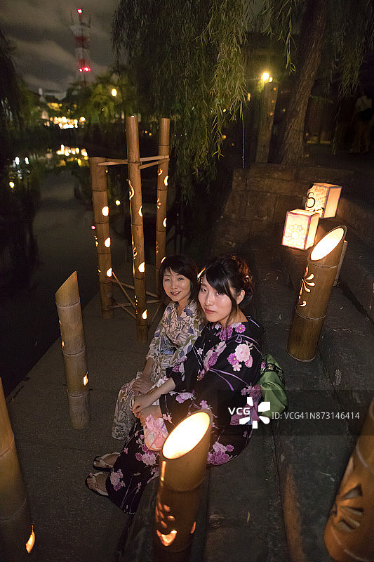 母女身穿浴衣坐在竹灯楼梯上图片素材
