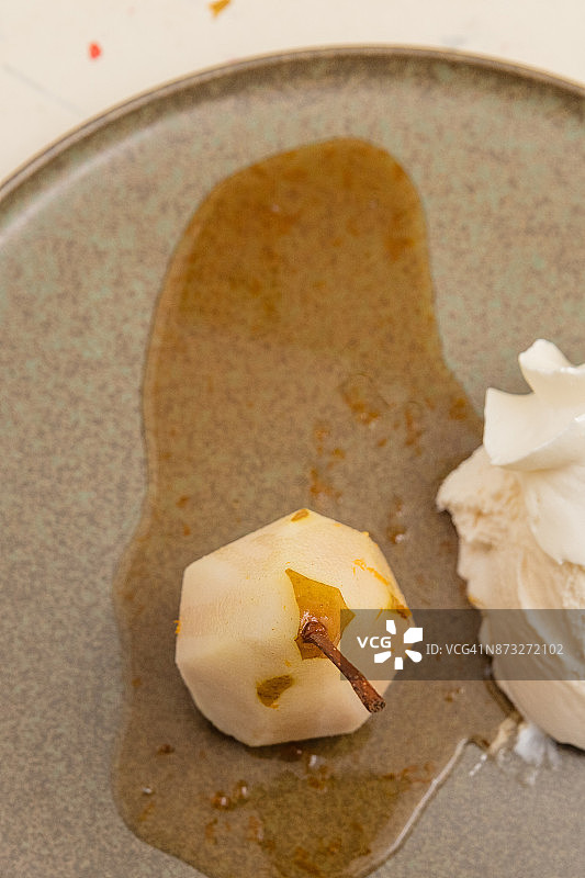 葡萄酒蒸杜隆多梨、酱汁、冰淇淋和鲜奶油拼盘图片素材