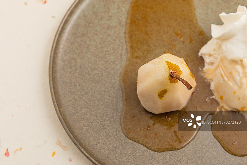 葡萄酒蒸杜隆多梨、酱汁、冰淇淋和鲜奶油拼盘图片素材