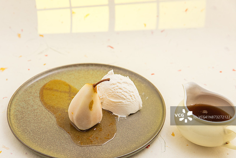 葡萄酒蒸杜龙多梨，搭配酱汁和冰淇淋图片素材