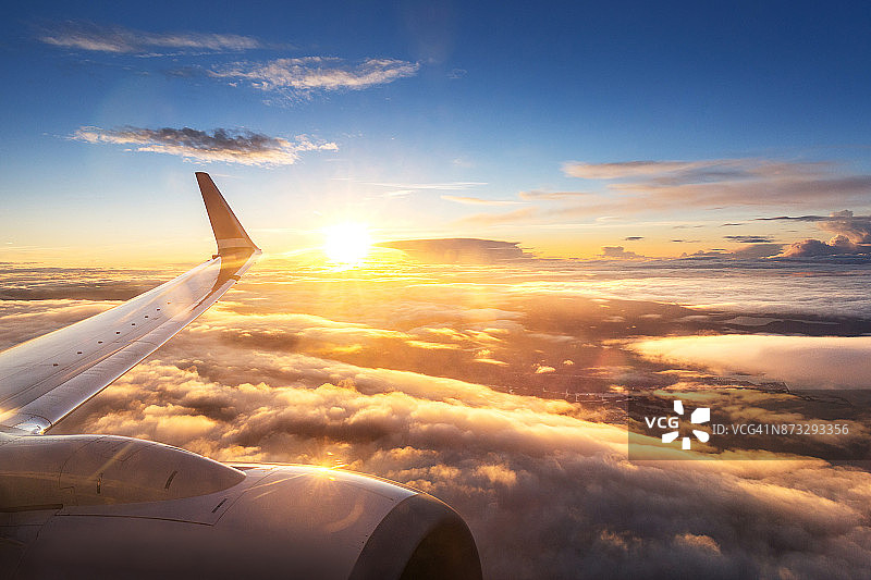 周五傍晚飞往丹麦哥本哈根的飞机舷窗外的日落天空图片素材