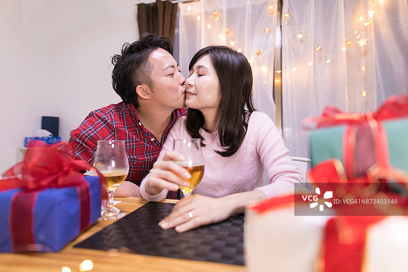 圣诞节夜晚年轻丈夫亲吻妻子图片素材