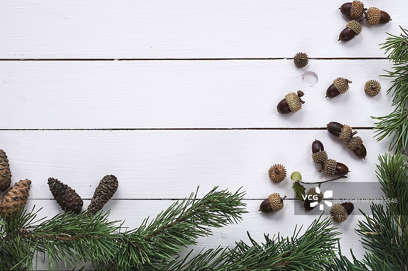 圣诞节框架俯视图：冷杉树、松果和橡子在彩绘木制背景上，留有复制空间图片素材