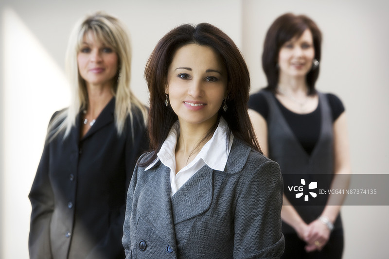 一位女性的肖像，背景中有两位其他人。图片素材