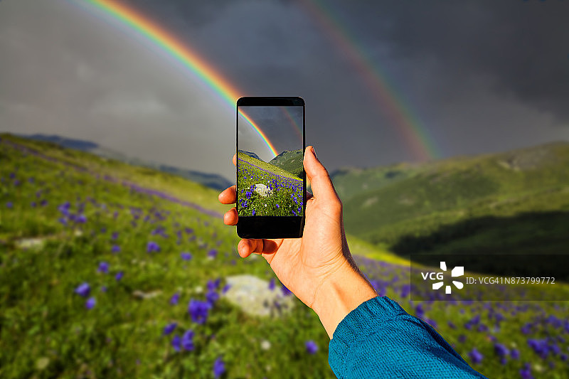 用智能手机拍摄：山间鲜花上的彩虹图片素材