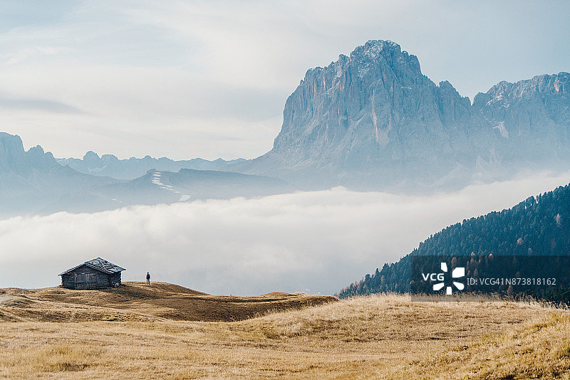 女人站在小屋旁欣赏意大利多洛米蒂山脉图片素材