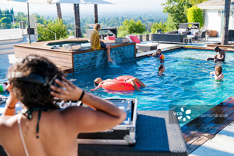 朋友们在豪华游泳池放松身心图片素材