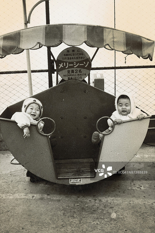 双胞胎婴儿在游乐设施上的肖像图片素材