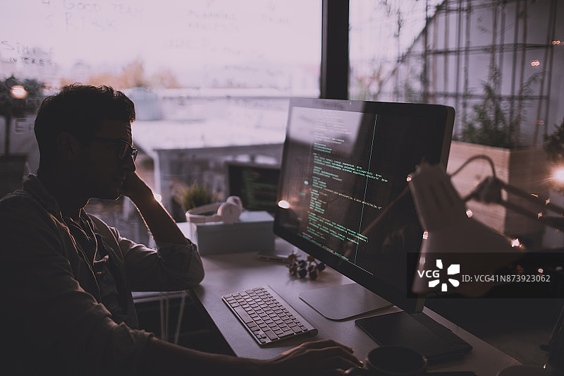 年轻男人在他的电脑上编程图片素材