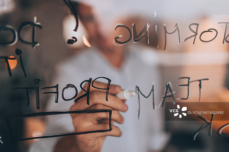 男人在透明板上书写图片素材