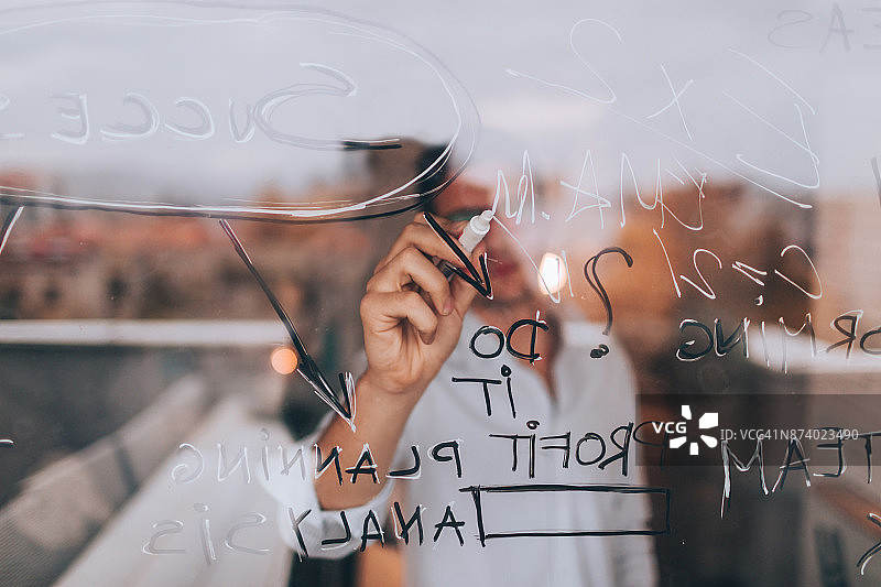 男人在透明板上书写图片素材
