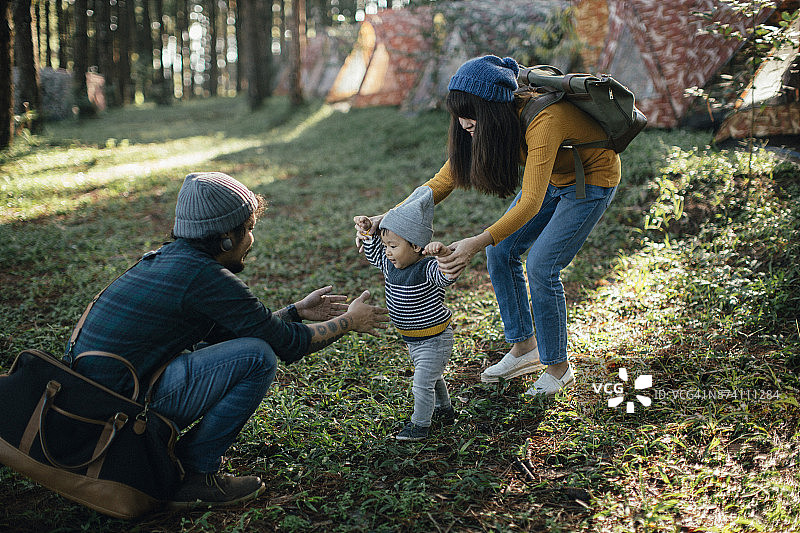 快乐的男婴在森林的草地上迈出第一步图片素材