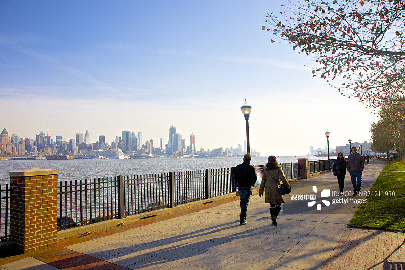 两对夫妇秋季在新泽西州威霍肯河滨长廊散步图片素材