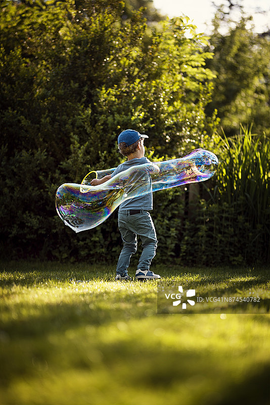 小男孩吹肥皂泡图片素材