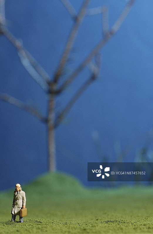 在冬日草坪上跋涉的微型雕像图片素材